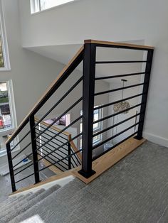 a stair case with metal railing and wood handrail