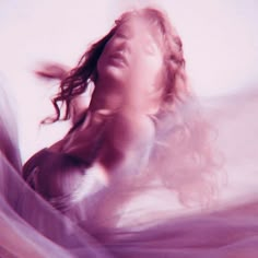 a blurry photo of a woman with her hair blowing in the wind and looking up