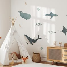 a child's room with a teepee tent and shark wall decals