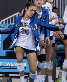 the women's volleyball team huddles around on the court