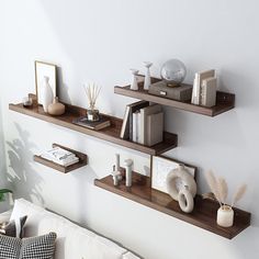 two shelves with books, vases and other items on them in a living room