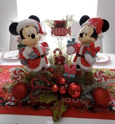 two mickey and minnie mouse figurines sitting on top of a table