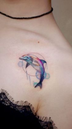 a woman's chest with a dolphin tattoo on it