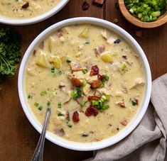 two bowls filled with soup on top of a wooden table