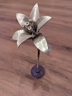 a metal flower sitting on top of a wooden table