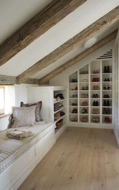 an instagram photo of a bedroom with white walls and wooden floors, built in shelving