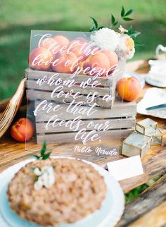 a wooden table topped with fruit and a sign