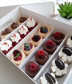 a box filled with lots of different flavored pastries on top of a table