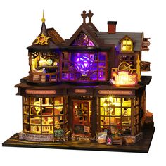 a doll house with lights and furniture in the shape of a store front window at night