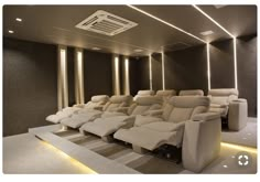 a row of reclining chairs in a room with lights on the ceiling and walls