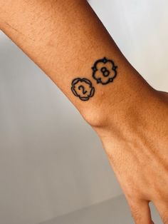 a person's hand with a flower tattoo on their left wrist and the word love written in black ink