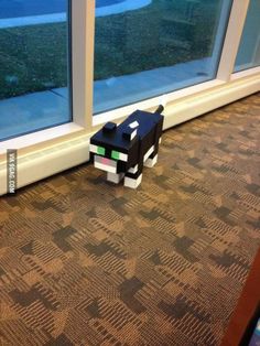 a paper toy sitting on the floor next to a window