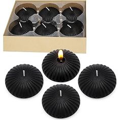 six black tealight candles in a cardboard box with the lid open to show them