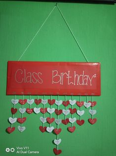 a sign that says class birthday with hearts hanging from it