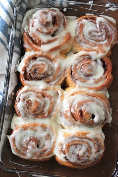 cinnamon rolls with icing in a glass baking dish