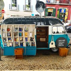 an old bus is parked on the side of the road with bookshelves attached to it