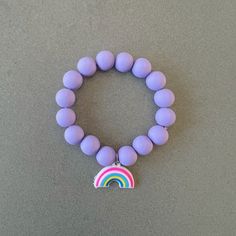 Purple bracelet for girl silicon bead bracelet little girl bracelet rainbow charm bracelet purple beaded bracelet kids bracelet rainbow gift This delightfully cute kids rainbow bracelet is perfect for your little one! Constructed with an elastic cord, it is both easy and safe for your child to put on and take off. The purple silicon beads, paired with the rainbow charm, make this bracelet the perfect accessory for your kid. Item Details *Material: Silicon beads, Elastic cord *Bracelet size: 6in Playful Rainbow Adjustable Charm Bracelet, Playful Adjustable Rainbow Charm Bracelet, Rainbow Adjustable Stretch Bracelet, Adjustable Purple Charm Bracelet For Birthday, Adjustable Rainbow Stretch Bracelet, Playful Hypoallergenic Purple Jewelry, Playful Purple Hypoallergenic Jewelry, Cute Rainbow Charm Bracelet For Gift, Cute Adjustable Rainbow Friendship Bracelets