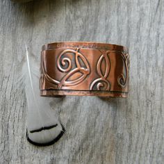 This bracelet is composed of 2 layers of copper. The top layer has been embossed with a romantic swirl pattern and then rivited to the bottom layer. The bottom layer has been hand hammered for a rustic texture. I then gave it a patina to bring out the details of the pattern. I've given it a coat of sealer to protect the patina. 6 inches long with a 1 inch opening. This is slightly adjustable for a custom fit for most wrist sizes. The cuff measures approximately 1.25 inches wide. See a narrower v Handmade Copper Bracelet, Floral Cuff Bracelet, Unique Dangle Earrings, Flower Cuff Bracelet, Floral Cuff, 7th Anniversary Gifts, Rustic Cuff, Cuff Bracelets Handmade, Anniversary Gift For Wife