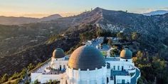 an aerial view of a large white building with two domes on it's roof