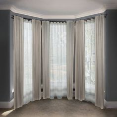 an empty room with curtains hanging on the windowsills and carpeted flooring