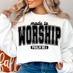 a woman wearing a white sweatshirt with the words made to worship printed on it