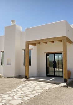 a white building with wooden pillars and doors