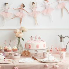 a table topped with cakes and cupcakes covered in pink icing