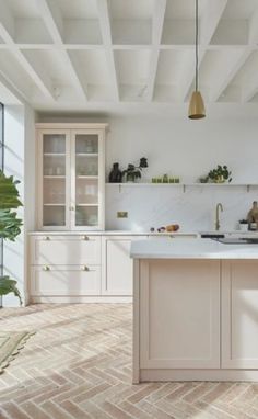 a kitchen with white cabinets and brick flooring