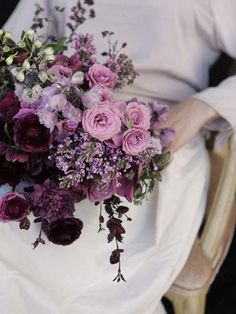 a woman holding a bouquet of flowers in her lap