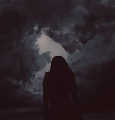 a person standing in front of a dark cloud