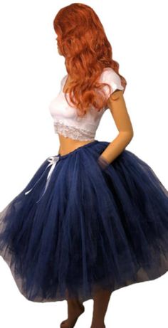 Step into elegance and grace with our Beautiful Navy Blue Tutu Skirt. This stunning skirt is perfect for any occasion, whether it's a special event, a party, or simply a day when you want to feel extra special. The skirt is meticulously crafted by tying hundreds of pieces of tulle to a comfortable elastic band. This technique creates a full and voluminous look, giving the skirt a mesmerizing and fluffy appearance. The deep navy blue color adds an element of sophistication, making you stand out with style and confidence. To add a touch of elegance, the skirt is adorned with a delicate white satin bow, creating a beautiful contrast against the navy blue tulle. This subtle detail adds an extra layer of charm and completes the overall look. Measuring at a length of 25 inches, this tutu skirt f Blue Skirt For Costume Party, Blue Skirt For Spring Costume Party, Blue Tulle Bottoms For Spring, Spring Blue Tulle Bottoms, Elegant Summer Skirt For Costume Party, Summer Wedding Skirt With Stretch, Elegant Tulle Bottoms For Party, Summer Tiered Skirt For Prom, Tiered Skirt For Summer Prom