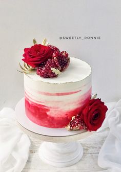 a white cake with raspberries and flowers on top