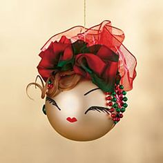 a christmas ornament with a woman's face and red roses on it