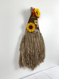 a wall hanging decoration with sunflowers and a scarecrow's hat on it