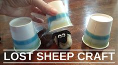 a hand is holding a cup with a stuffed animal in it and the words lost sheep craft above it