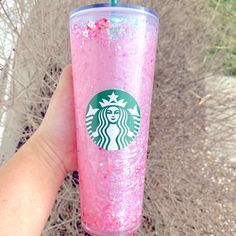 a hand holding a pink starbucks cup with sprinkles