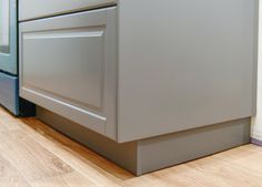 a close up view of a kitchen cabinet with wood flooring and white walls in the background