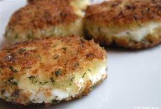 three crab cakes are on a white plate