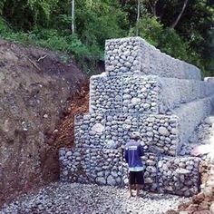 a man standing next to a pile of rocks