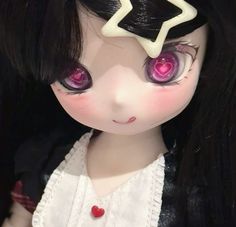 a close up of a doll with long black hair and pink eyeliners on her face