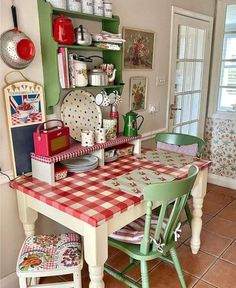 a kitchen with green cabinets and red checkered table cloth