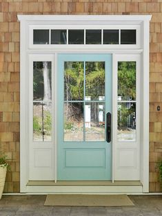 a blue front door sitting next to a brick building