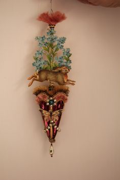 a clock hanging from the side of a wall with flowers on it's face