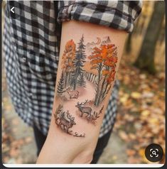 a person with a deer and trees tattoo on their arm, showing the forest scene