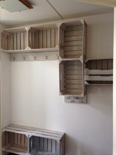 a room with some wooden boxes on the wall and shelves above it that are empty