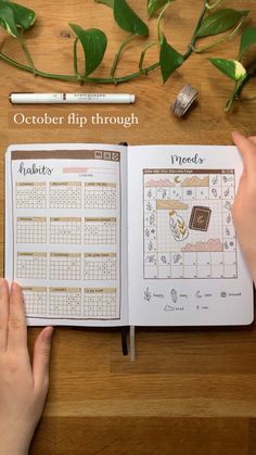 a person is holding a planner in their hand and looking at the calendar on top of a table