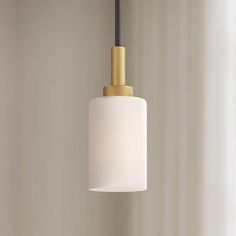 a white and gold light hanging from a ceiling fixture in a living room or bedroom