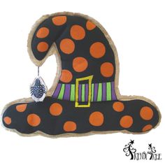 a black hat with orange and green polka dots on the top is hanging from a hook