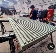 a man working on a metal structure in a factory