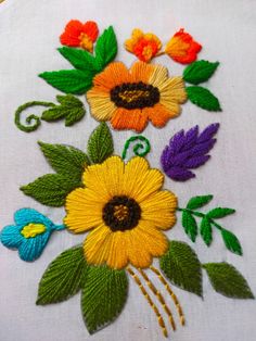 an embroidered piece with flowers and leaves on it